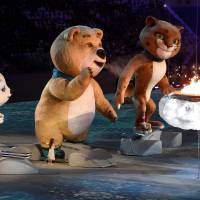 The rabbit, polar bear and leopard mascots stand in front of a small cauldron as they prepare to extinguish it. | AFP-JIJI