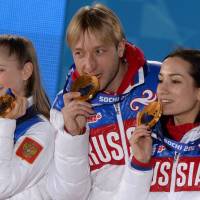 Russian gold medalist Evgeni Plushenko (center) and Julia Lipnitskaia (left) pose with fellow teammates during the medal ceremony for the figure skating team competition on Sunday. | AFP-JIJI