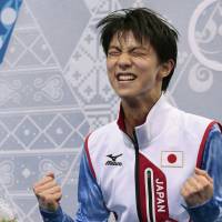 Yuzuru Hanyu of Japan reacts after receiving a high score for his short program. | AP