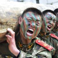 Chinese troops lift a log during a training session in January at a base in Chaohu, Anhui province. | REUTERS