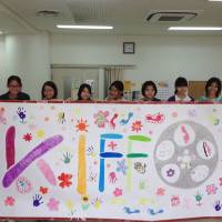 Children involved in the Kinder International Film Festival in Okinawa hold up their design for a special KIFFO opening carpet. | KIFFO