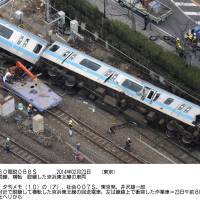 A derailed Keihin Tohoku Line train lies near JR Kawasaki Station after hitting a maintenance car Sunday. | KYODO