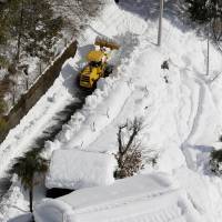 Houses in Hayakawa, a remote town in Yamanashi Prefecture, are surrounded by snow on Monday, preventing residents from acquiring necessities or receiving assistance. | KYODO