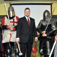 Ready for battle: Japan Armored Battle League CEO Jay Noyes (center, wearing a suit), with JABL fighters and assistants, celebrate the league\'s opening event at the Pink Cow in Roppongi, Tokyo. | YOSHIAKI MIURA