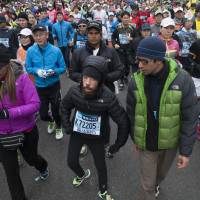 On your marks: Melamed, flanked by supporters, tackles the Tokyo Marathon last Sunday. | NATALIE HOWARD