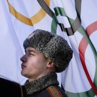 Proud people: A member of a Russian honor guard listens to the Olympic anthem during a welcome ceremony for the German Olympic team at the Mountain Olympic Village prior to the 2014 Winter Olympics on Wednesday in Krasnaya Polyana, Russia. | AP