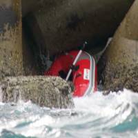 Mystery find: A dinghy in which the body of a Cabinet Office staffer was spotted sits in a breakwater Jan. 18 near Kitakyushu. | WAKAMATSU COAST GUARD/KYODO