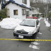 Off-limits: A police officer stands watch near the scene where a man allegedly stabbed a 17-year-old girl to death in Hachioji, Tokyo, on Thursday. | KYODO