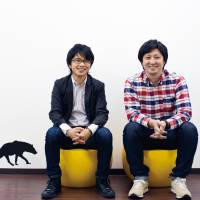 Takuma Kobayashi (left), the president of cloud funding firm Search Field Inc., and board member Ryuta Saito pose for a photo at the company’s office in Shibuya Ward, Tokyo. | WEDGE