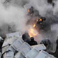 Policemen are pelted with Molotov cocktails during battles with anti-government protesters in front of the Ukrainian Parliament in Kiev on Tuesday.　 | AFP-JIJI