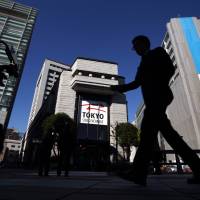 A pedestrian walks past the Tokyo Stock Exchange on Dec. 24, 2013. Merger of Jasdaq, Mothers, second section eyed