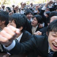 Vocational school students raise their fists during a rally in Tokyo to start off their hunt for a job in January | BLOOMBERG