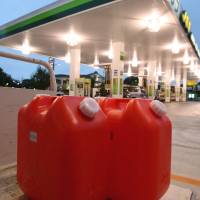 Containers of kerosene stand outside a gasoline station in the city of Chiba. | BLOOMBERG