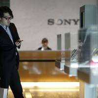 Considering the options: Visitors view Sony Corp. products at the company\'s headquarters in Tokyo on Feb. 6. | BLOOMBERG