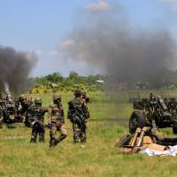No end in sight: Philippine soldiers fire 105mm howitzer canons toward rebels during a clash near Rajah Buayan, Maguindanao province, on Jan 28. | AFP-JIJI