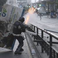 A National Guard member clashes with anti-government protesters in Caracas on Saturday. | AFP-JIJI