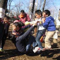 Kids in Tokyo\'s Kiba Park swing on a rope bridge, one of the activities available for free at Kiba Playpark. |  KAORI SHOJI