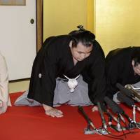 Kakuryu is flanked by stablemaster Izutsu (right) and his stablemaster\'s wife at Hoganji temple in Tennoji Ward, Osaka, on Wednesday upon being named yokozuna.
 | KYODO