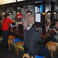 Fare stage: Diners at a Noodle Street eatery beneath the station. | STEPHEN CARR PHOTOS