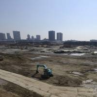Power shovels operate in the Toyosu area of Tokyo on Sunday. Data released Tuesday shows that both residential and commercial land prices in major cities jumped in 2013. | BLOOMBERG
