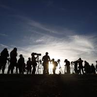 Television crews wait for an aircraft tasked with hunting for wreckage from Malaysia Airlines Flight MH370 to arrive at Pearce air base near Perth, Western Australia, on Friday. | REUTERS
