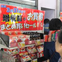 People shop at a Takeya discount store in Taito Ward, Tokyo, on Monday, the day before the consumption tax rises to 8 percent from 5 percent to slow Japan’s ballooning debt. Shoppers flock to stores ahead of sales tax hike