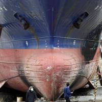 The Kyotoku Maru No. 18, a 330-ton vessel swept over 700 meters inland by the March 11 tsunami, towers above passers-by in Kesennuma, Miyagi Prefecture. The ship was removed last October. | AP