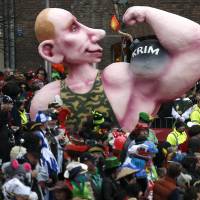 A carnival float with a papier-mache caricature of Russian President Vladimir Putin flexing his muscle, with the word \'Crimea\' written on it, takes part in the traditional Rose Monday carnival parade in the western German city of Duesseldorf on Monday. | REUTERS