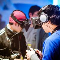 BitSummit attendees try out games made for the Oculus Rift virtual-reality headset such as \"Project life.\"  | DYLAN CUTHBERT