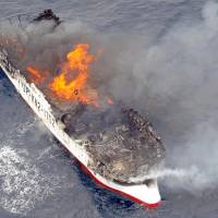 Thick black smoke rises from the trawler Kaisei Maru No. 8 as it is engulfed in flames after catching fire about 400 km south of Kochi Prefecture on Sunday. | KYODO