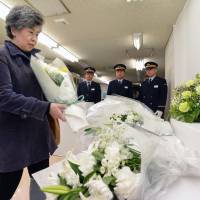 Shizue Takahashi, widow of deputy stationmaster Kazumasa Takahashi, adds a bouquet to the offering of flowers for sarin gas attack victims at the 19th annual memorial ceremony Thursday in Kasumigaseki Station in Chiyoda Ward, Tokyo. Workers, relatives remember deadly Aum sarin attack on 19th anniversary