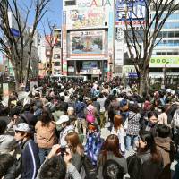 A crowd gathers outside the Studio Alta building in Shinjuku Ward, Tokyo, to watch the final episode of the Fuji TV show \"Waratte Iitomo!\" live on a giant screen Monday. | KYODO