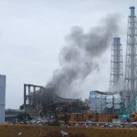 Smoke signal: Wreckage of the Reactor 3 building at Fukushima No. 1 nuclear power plant as seen in a photo released by the operator, Tokyo Electric Power Co., on March 21, 2011. That reactor is now one of three in meltdown at the site. | AP