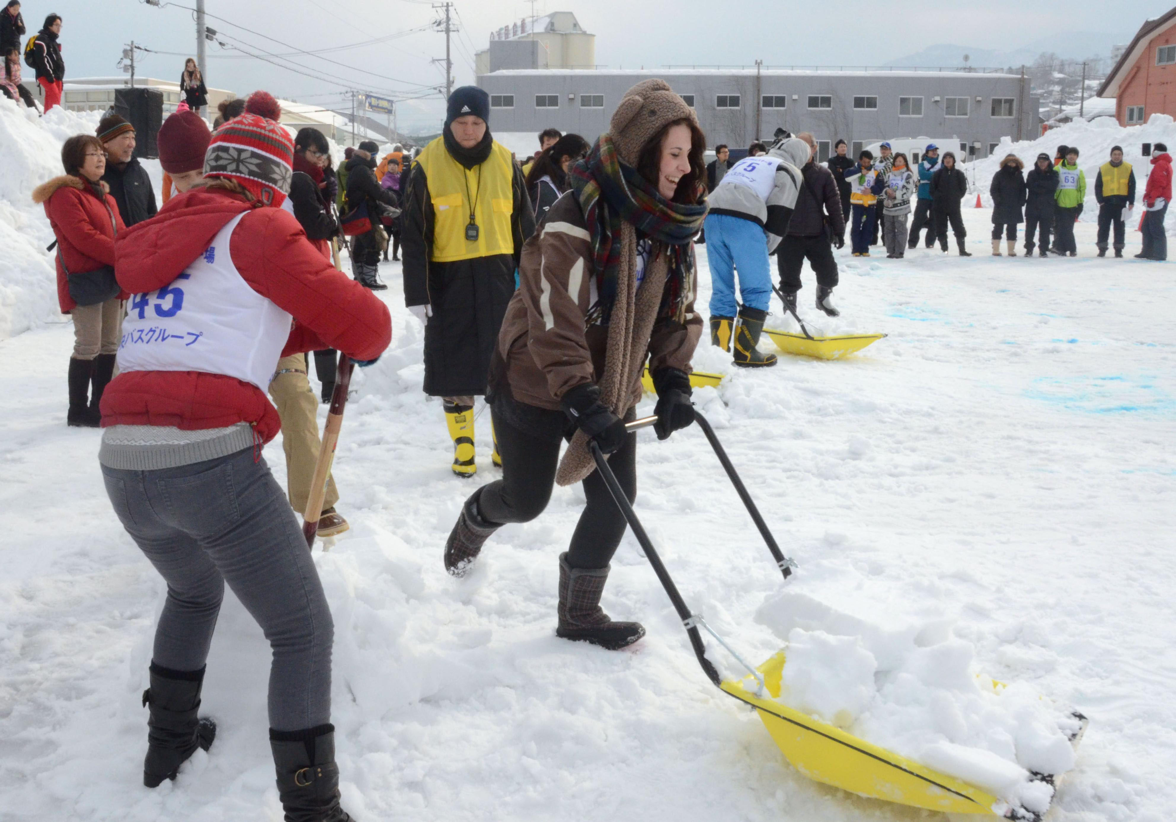 Participants scoop and carry snow in an international competition on snow shoveling held in Otaru, Hokkaido, in January. | KYODO