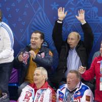 Russian President Vladimir Putin, Prime Minister Dmitry Medvedev (top, second from left) and Sports Minister Vitaly Mutko (top left) watch an ice sledge hockey game between Russia and South Korea at the 2014 Winter Paralympics in Sochi, Russia, on March 8. South Korea won the game 3-2. Putin's games end under Crimea cloud