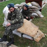 Ukrainian Air Force pilots sit on sandbags at the Belbek air base near Sevastopol the same day. Crimea crisis leaves Ukraine troops in limbo