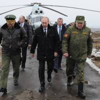 Russian President Vladimir Putin (center), Defense Minister Sergei Shoigu (left) and Anatoly Sidorov, the commander of the Western Military District, walk upon arrival to watch military exercise near St. Petersburg, Russia, on Monday. | AP