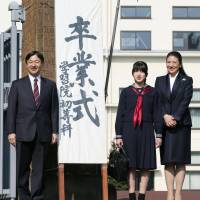 Princess Aiko, flanked by her parents, Crown Prince Naruhito and Princess Masako, stands at the gate to Gakushuin Primary School in Tokyo before attending her graduation ceremony Tuesday. | KYODO