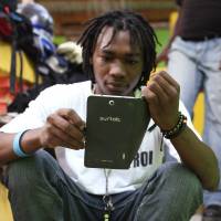 Artist Richard Josue uses a Surtab tablet, an Android-based tablet assembled in Haiti from imported components, along a sidewalk in Port-au-Prince on Sunday. | REUTERS