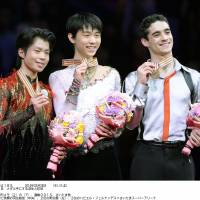Their time to shine: Gold medalist Yuzuru Hanu (center), compatriot Tatsuki Machida (left), who claimed the silver, and Spain\'s Javier Fernandez, the bronze medalist, share the spotlight on the podium on Friday. | KYODO
