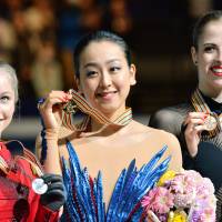 Center stage: Gold medalist Mao Asada (center), silver medalist Julia Lipnitskaia of Russia (left) and third-place finisher Carolina Kostner of Italy attend the award ceremony on Saturday night. | AFP-JIJI