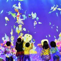 Computer-scanned children\'s drawings of fish are projected onto a big screen with special motion effects at Osaka Aquarium Kaiyukan this week. The service runs through Monday. | KYODO