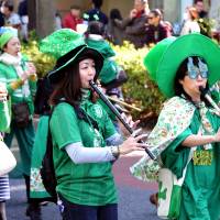 Women take part in a St. Patrick\'s Day parade Sunday in the Omotesando neighborhood of Tokyo. A number of Irish festivals are scheduled for this month across the country. | YOSHIAKI MIURA