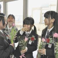 Students at Mano Elementary School in disaster-hit Minamisoma, Fukushima Prefecture, cry as they say their goodbyes after their graduation ceremony Thursday. Only 10 students graduated this year from the school, which will merge with another next month due to declining enrollment. | KYODO