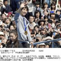 Golden child: Yuzuru Hanyu waves to fans during a parade in Sendai. | KYODO