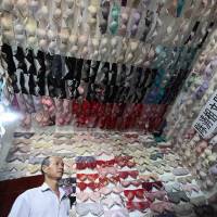 Chen Qingzu stands in a room whose walls and ceiling are covered with bras he collected to raise awareness of breast cancer in the Chinese city of Sanya, Hainan province, on Tuesday. Chen has gathered about 5,000 bras in the past 20 years as he toured China to organize public benefit activities related to breast cancer. | REUTERS