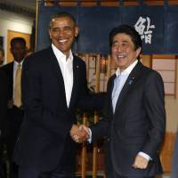 U.S. President Barack Obama is welcomed to the restaurant Sukiyabashi Jiro by Prime Minister Shinzo Abe in Tokyo on Wednesday. | REUTERS
