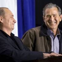 U.S. President George W. Bush shares a laugh with Russian President Vladimir Putin as the two answer questions at a high school in Crawford, Texas, in November 2001. | REUTERS