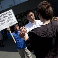 No entry: A student protester (right) is prevented from entering the Hosei University campus in Ichigaya, Tokyo, during a rally organized by the Bunka Renmei (Culture League) student group on Friday. The group is calling for disciplinary measures taken against students for their role in past protests to be repealed. | DAMON COULTER