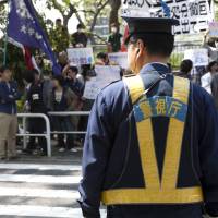 Ground zero: A policeman keeps watch at a student demo at Hosei University in Ichigaya, Tokyo, on Friday. | DAMON COULTER